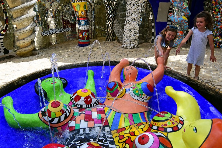 Two girls play with a fountain at Il Giardino dei Tarocchi in Capalbio, Italy on Wednesday, June 15, 2016. Il Giardino dei Tarocchi was created by artist Niki de Saint Phalle.